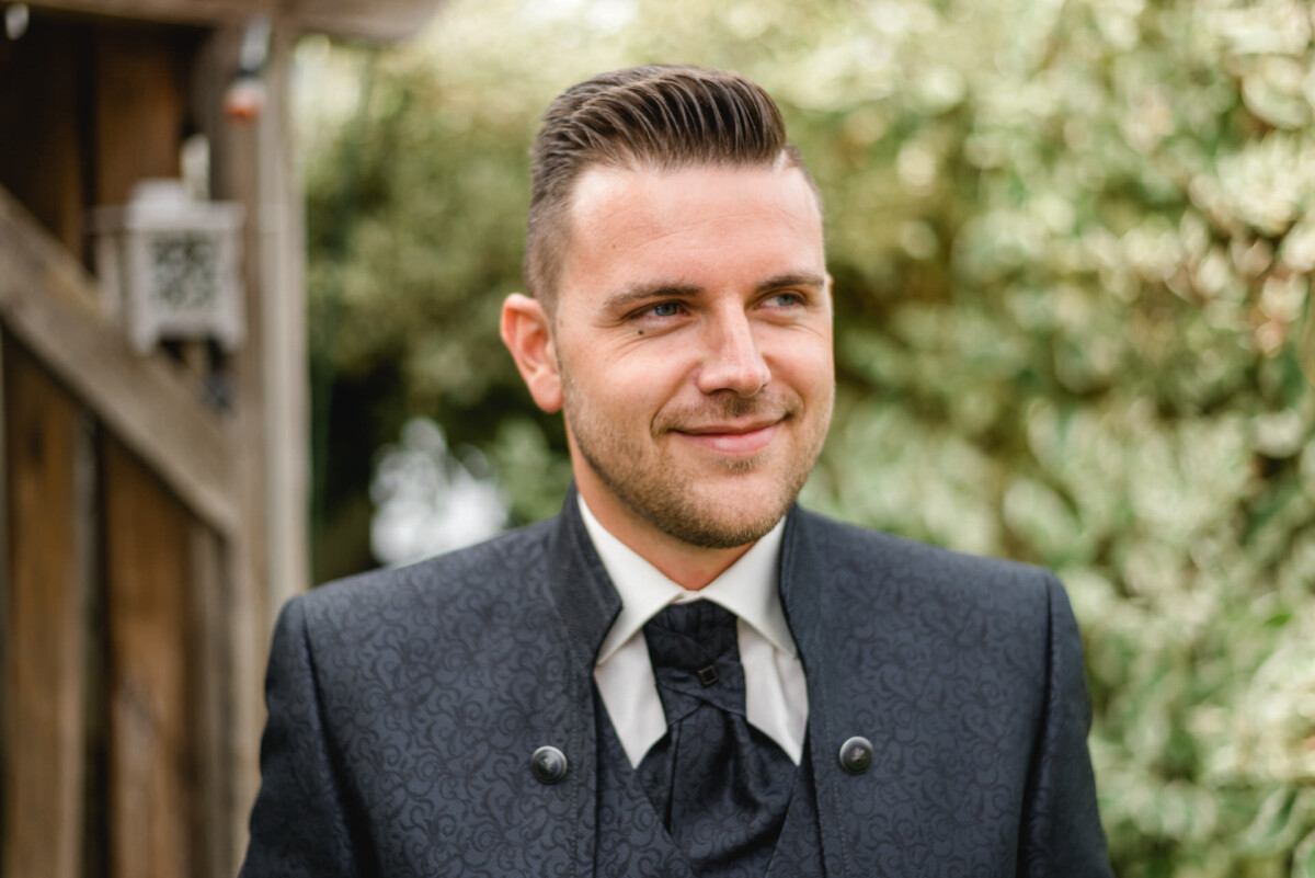 Janina_Daniel_Ettringen_00002 ein mann in anzug und krawatte steht draußen in Wehringen