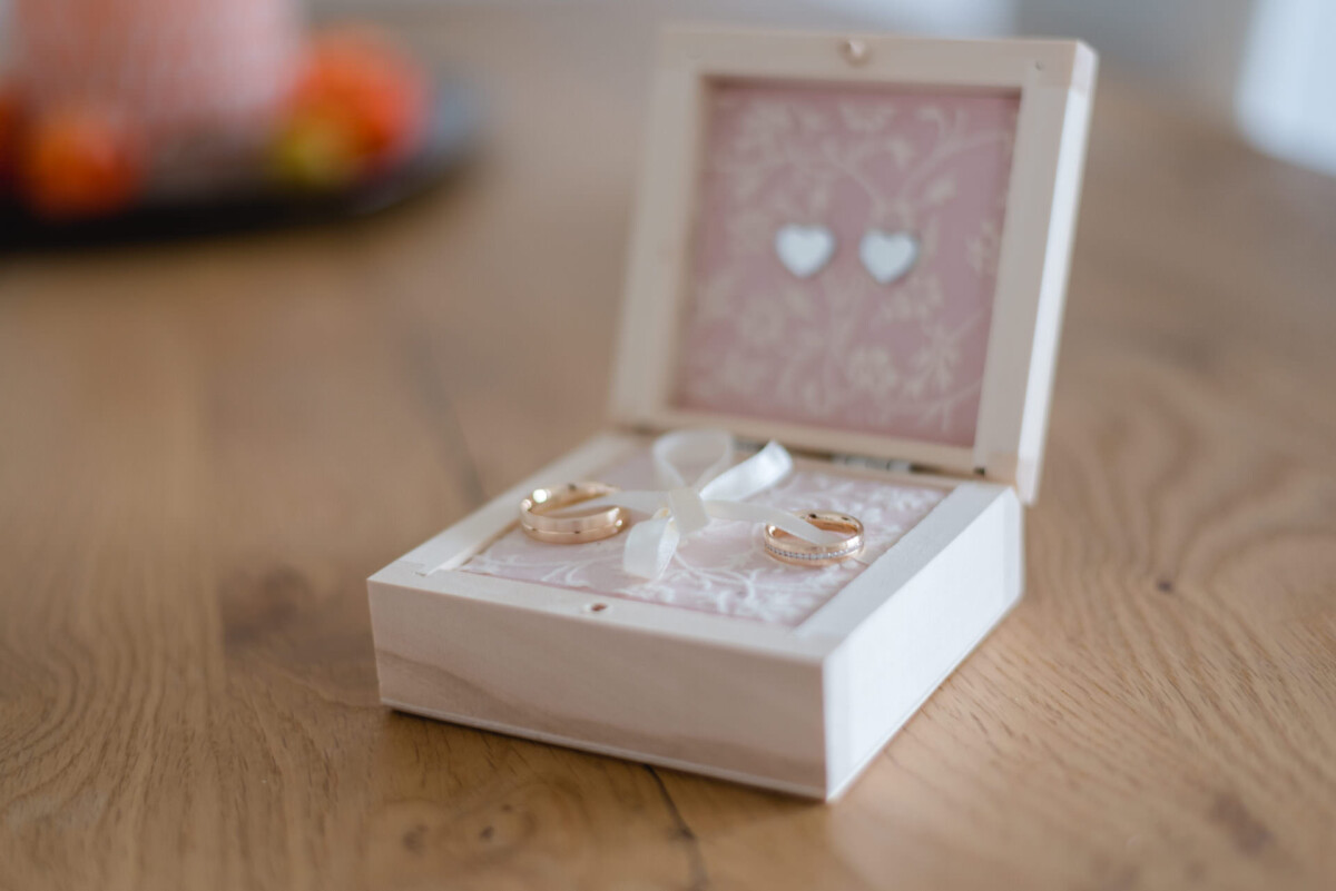 Janina_Daniel_Ettringen_00004 Zwei Trauringe in einer Schachtel auf einem Tisch in Bobingen