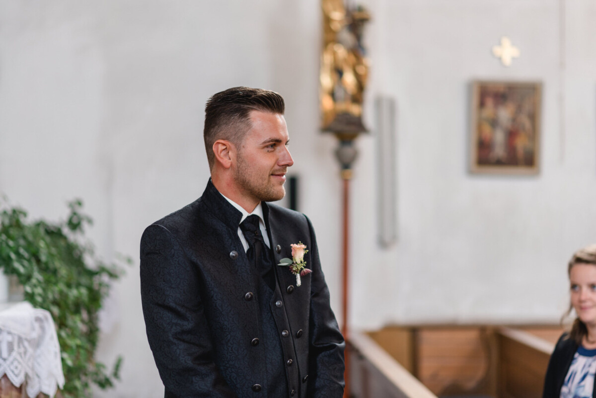 Janina_Daniel_Ettringen_00007 Ein Mann in Anzug und Krawatte steht in einer Kirche.