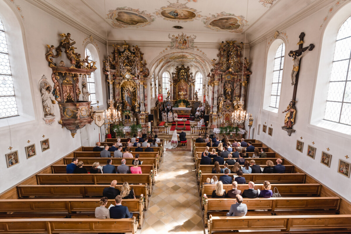 Janina_Daniel_Ettringen_00010 eine Gruppe von Menschen, die in Kirchenbänken sitzen.