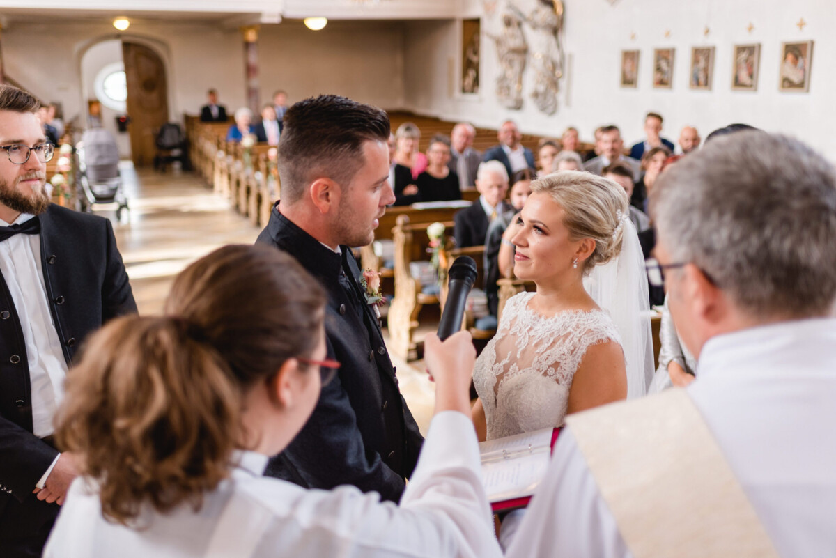 Janina_Daniel_Ettringen_00012 Ein Mann und eine Frau stehen vor einem Priester.