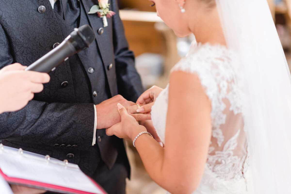 Janina_Daniel_Ettringen_00013 Ein Mann und eine Frau tauschen einen Ehering aus.