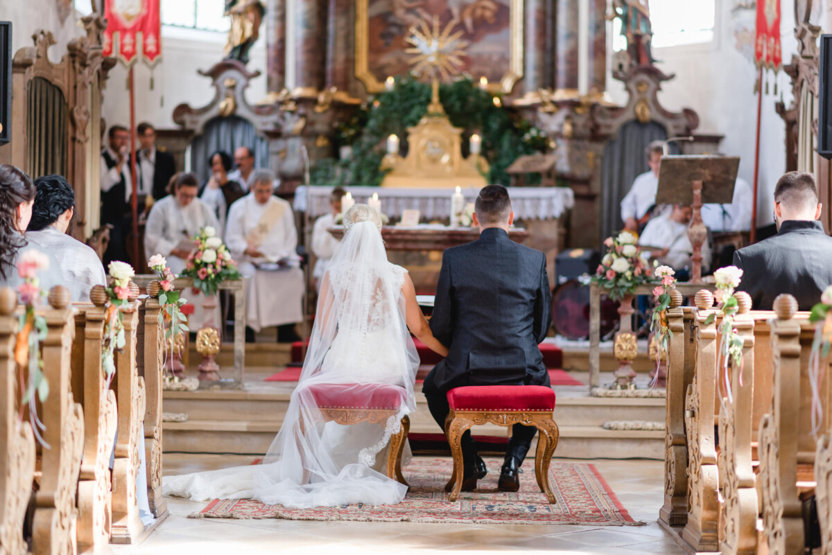 Janina_Daniel_Ettringen_00015 Ein Brautpaar sitzt am Altar.
