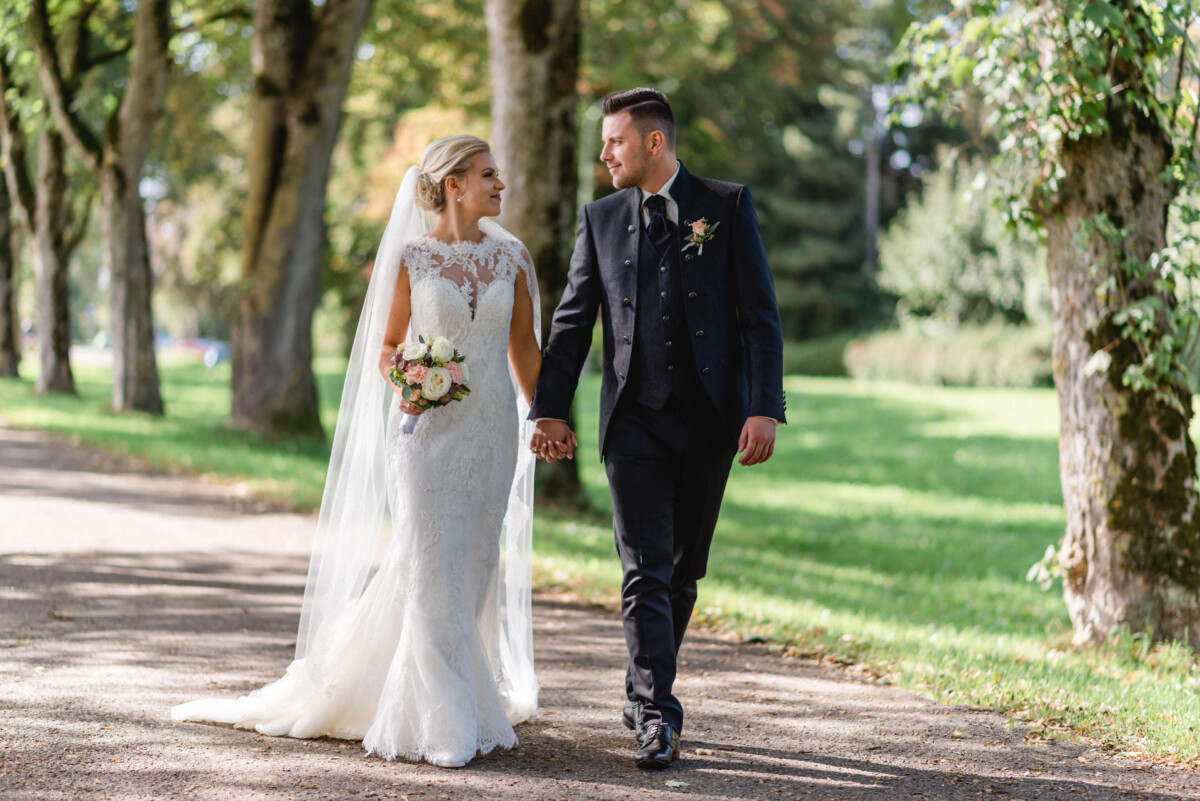 Janina_Daniel_Ettringen_00019 ein Brautpaar, das einen Weg hinuntergeht.