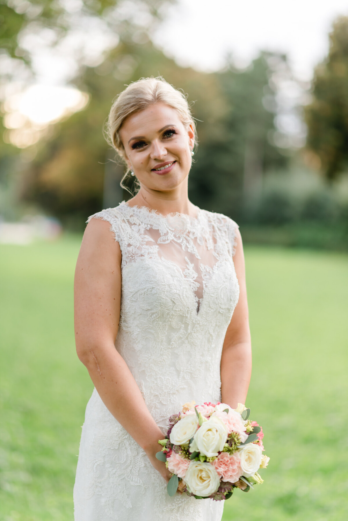 Janina_Daniel_Ettringen_00028 eine Frau in einem Hochzeitskleid, die einen Blumenstrauß hält.