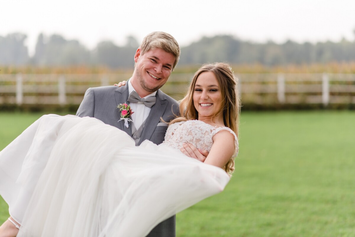 Julia_Marco_Donauwoerth_00003 Ein Mann und eine Frau halten ein weißes Kleid.