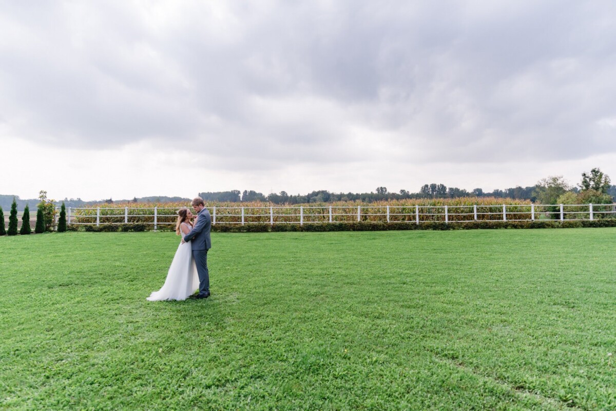 Julia_Marco_Donauwoerth_00007 eine Braut und ein Bräutigam, die auf einem Feld stehen.