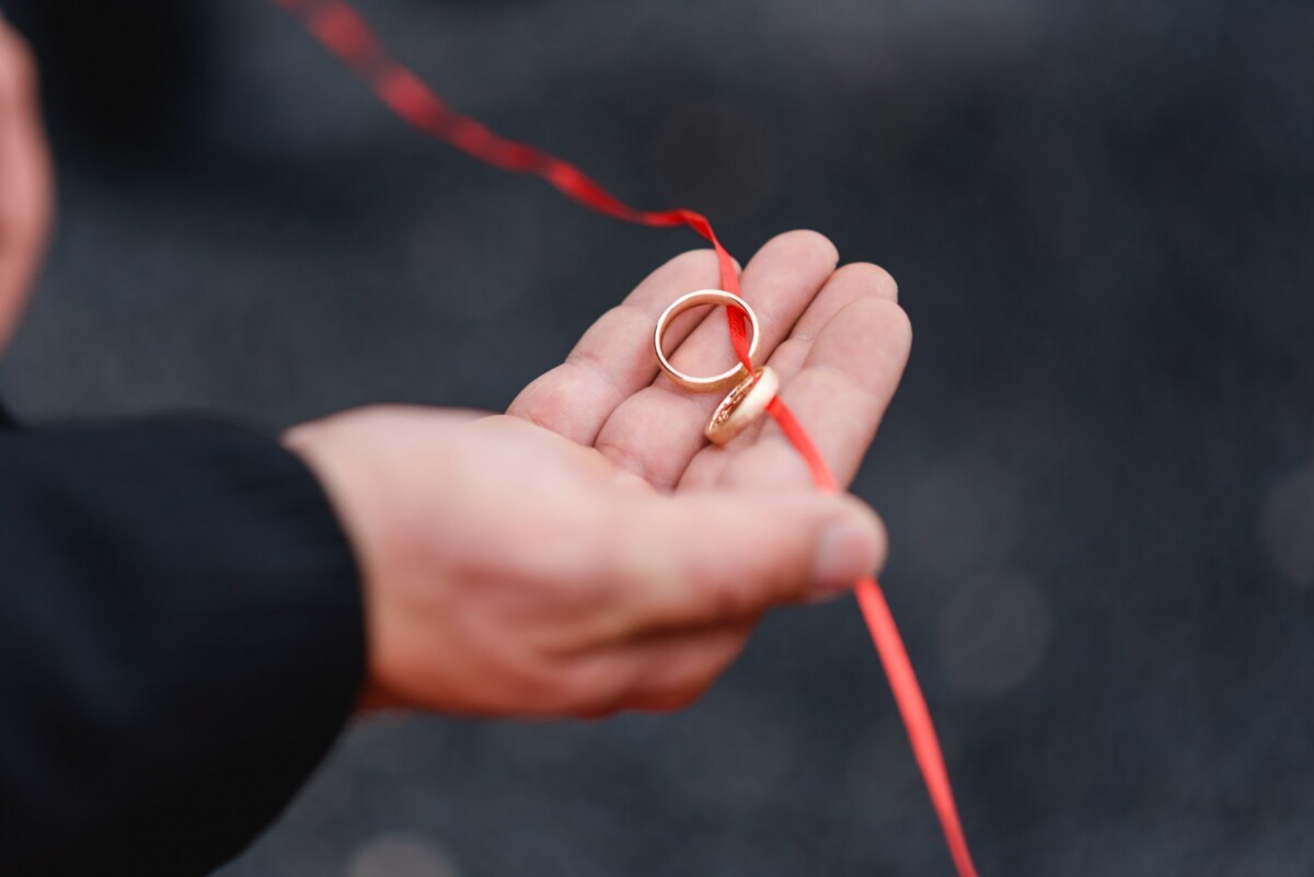 Julia_Marco_Donauwoerth_00016 eine Person, die ein Paar goldene Eheringe hält.