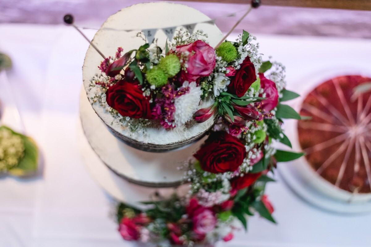 Julia_Marco_Donauwoerth_00017 ein dreistöckiger Kuchen mit Blumen darauf.