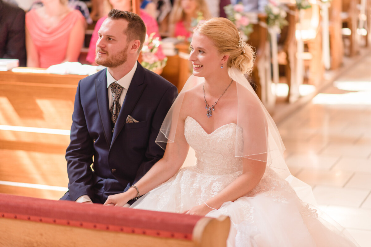 Natalie_Willi_Sulzemoos_00004 Ein Mann und eine Frau sitzen in einer Kirche.