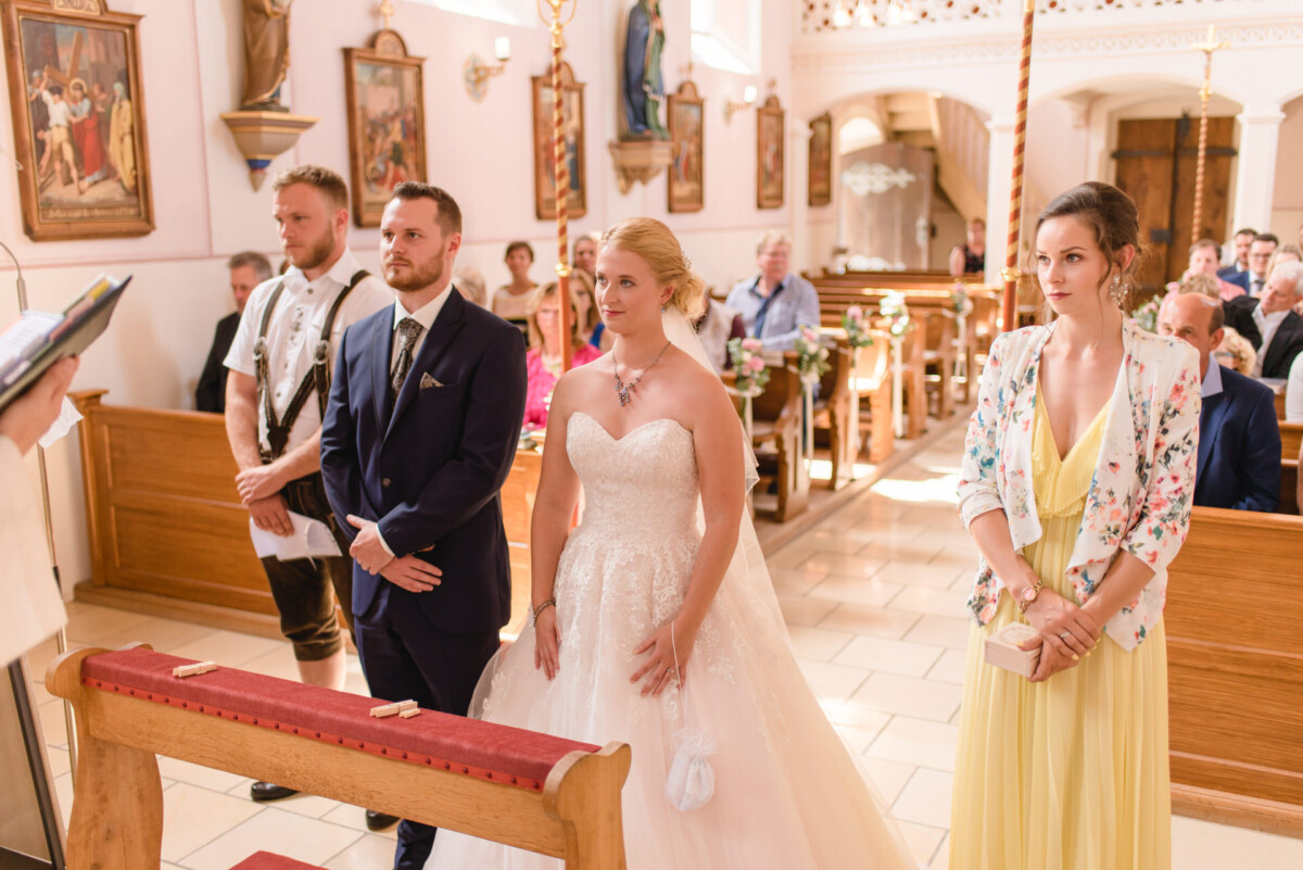 Natalie_Willi_Sulzemoos_00008 Ein Brautpaar steht in einer Kirche.