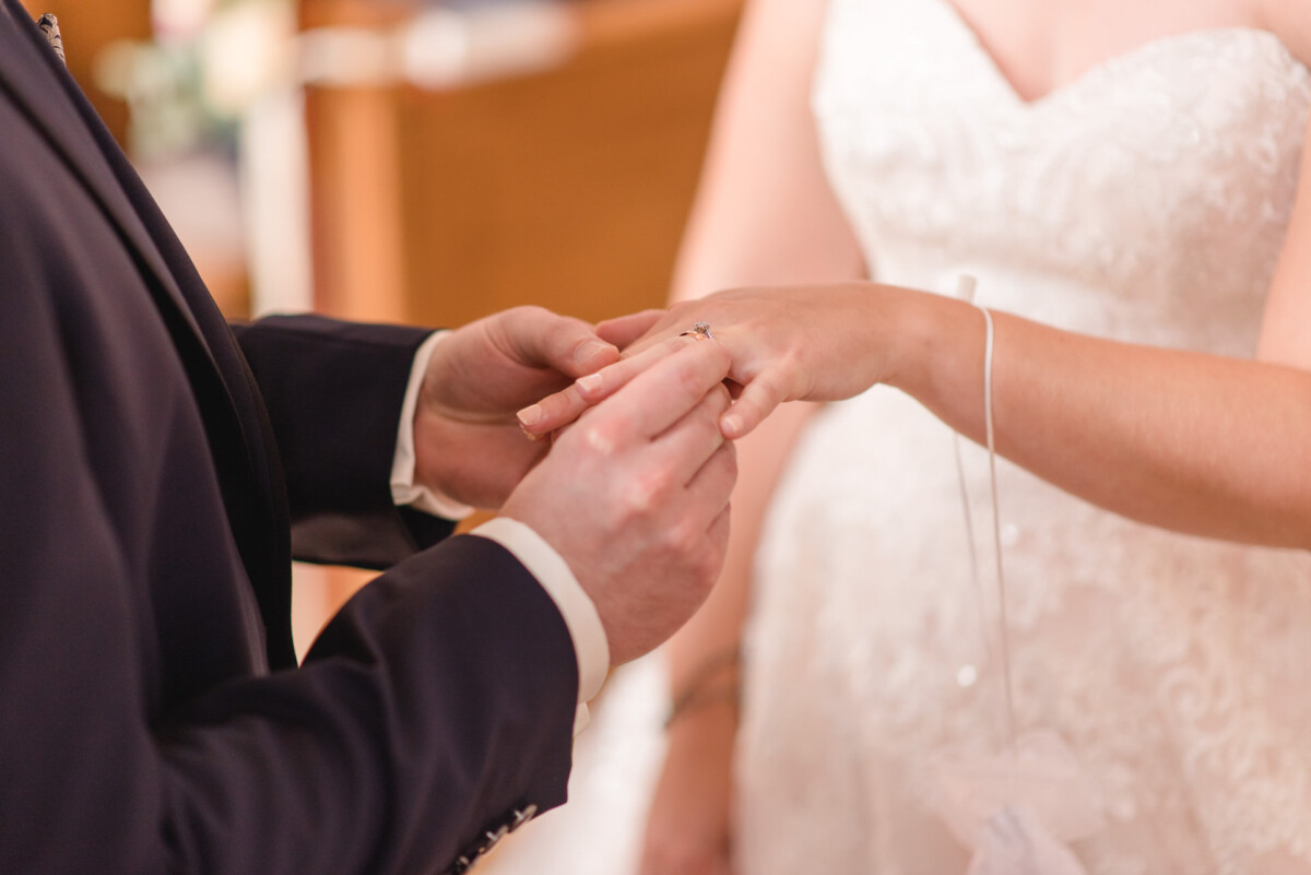 Natalie_Willi_Sulzemoos_00011 Ein Mann und eine Frau, die während einer Hochzeitszeremonie Händchen halten.