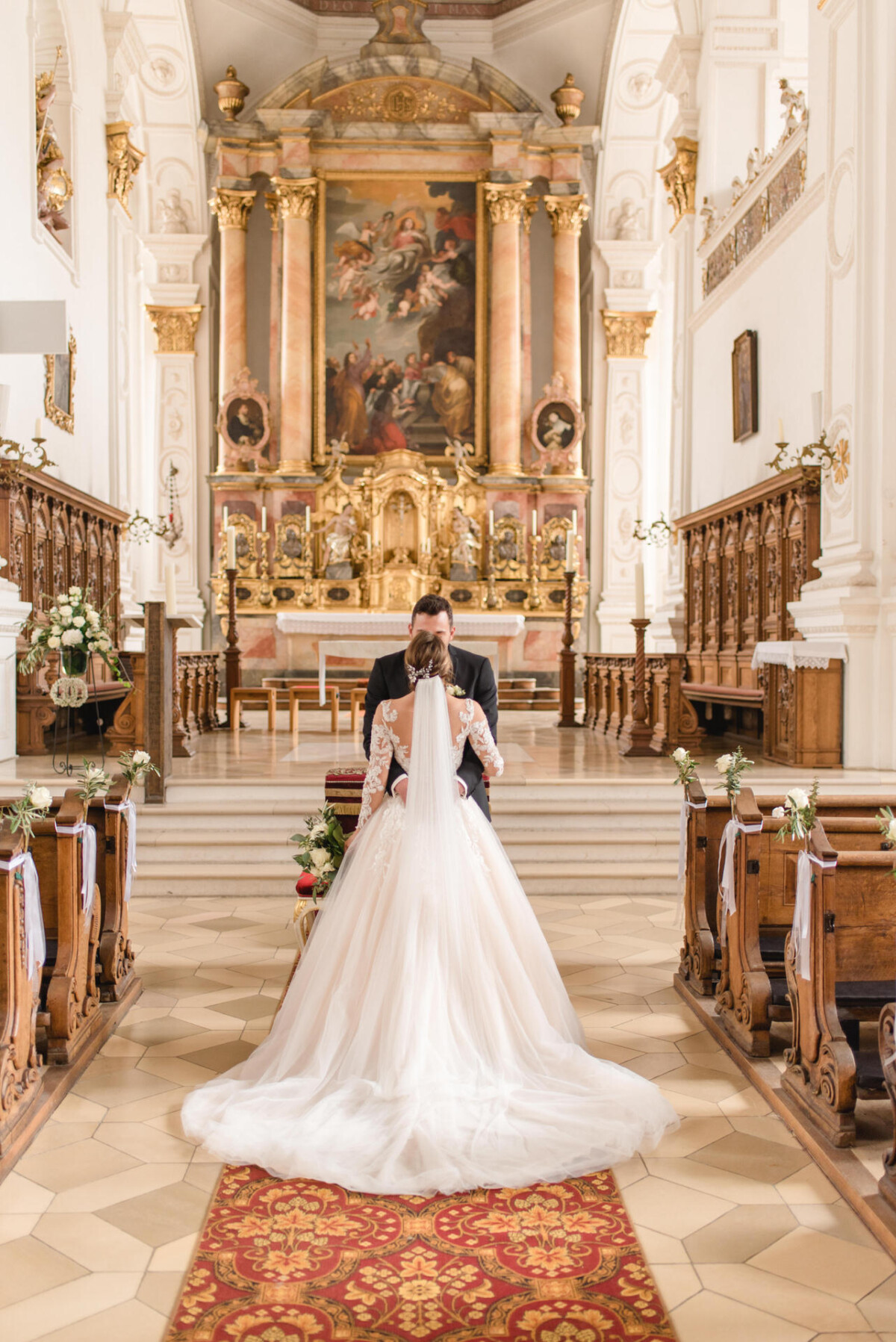 Sophia_Riccardo_Ammersee_00015 Ein Brautpaar steht in einer Kirche.