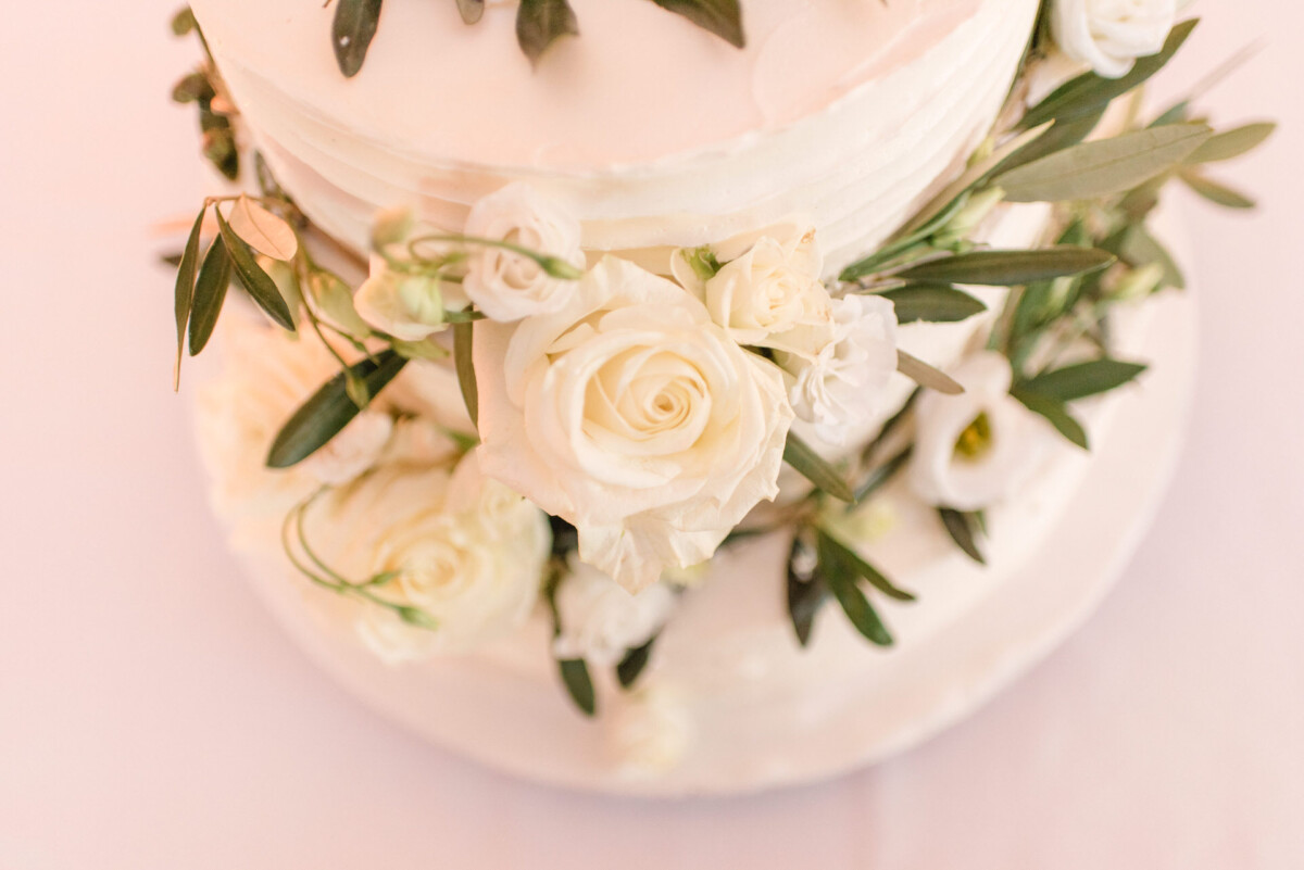 Sophia_Riccardo_Ammersee_00020 eine Hochzeitstorte mit weißen Blumen und viel Grün.
