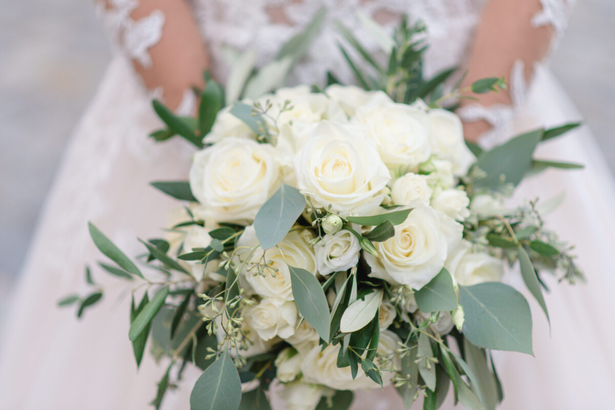 Sophia_Riccardo_Ammersee_00034 eine Braut, die einen Strauß weißer Blumen hält.