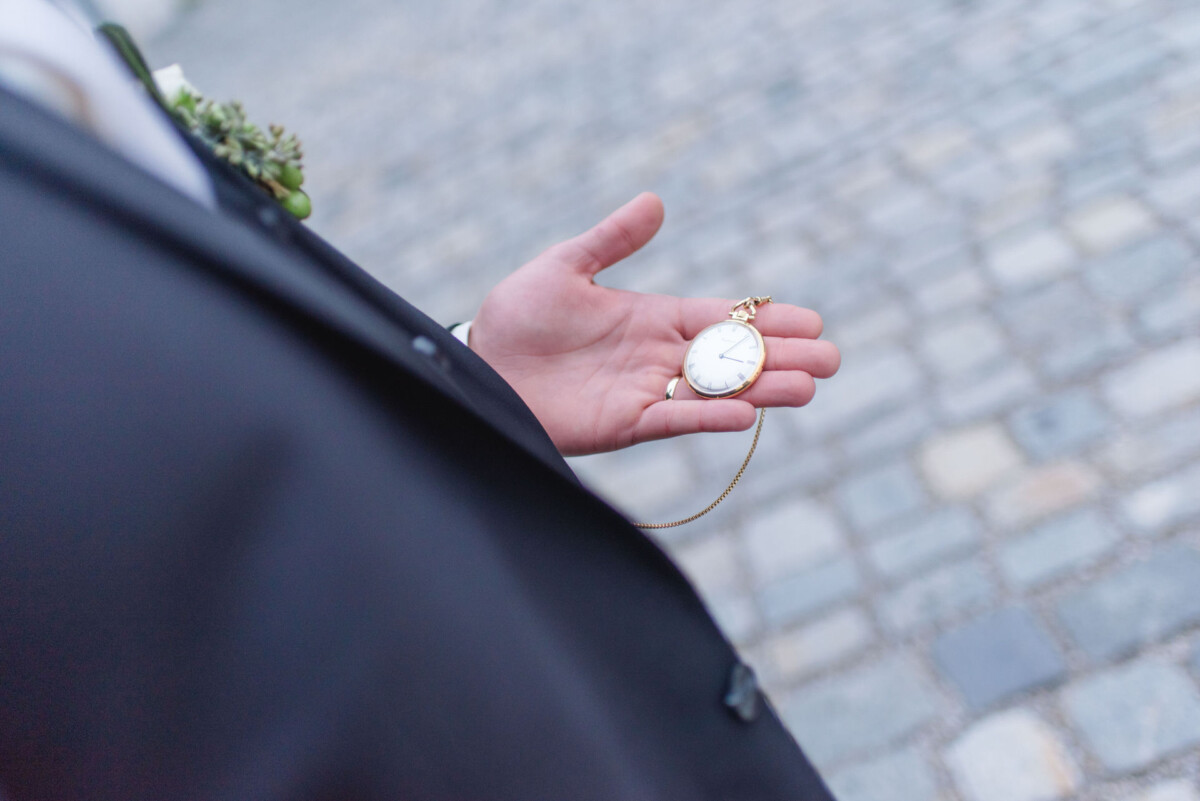 Sophia_Riccardo_Ammersee_00039 ein Mann im Anzug mit einer Taschenuhr.