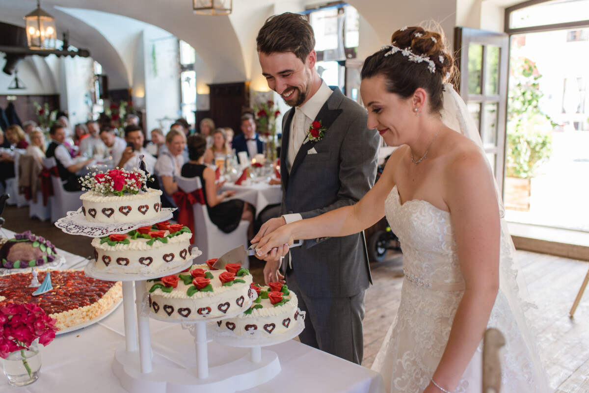 Stephi_Manu_Landsberg_am_Lech_00013 Braut und Bräutigam schneiden ihre Hochzeitstorte an.