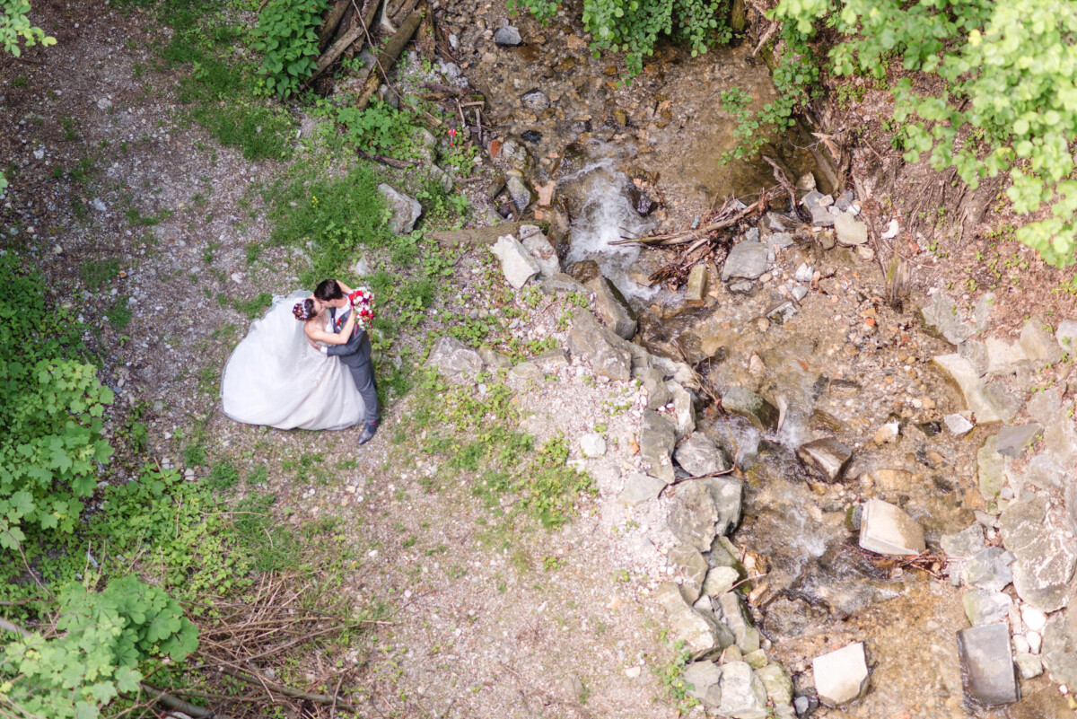 Stephi_Manu_Landsberg_am_Lech_00017 Ein Brautpaar steht neben einem Bach.