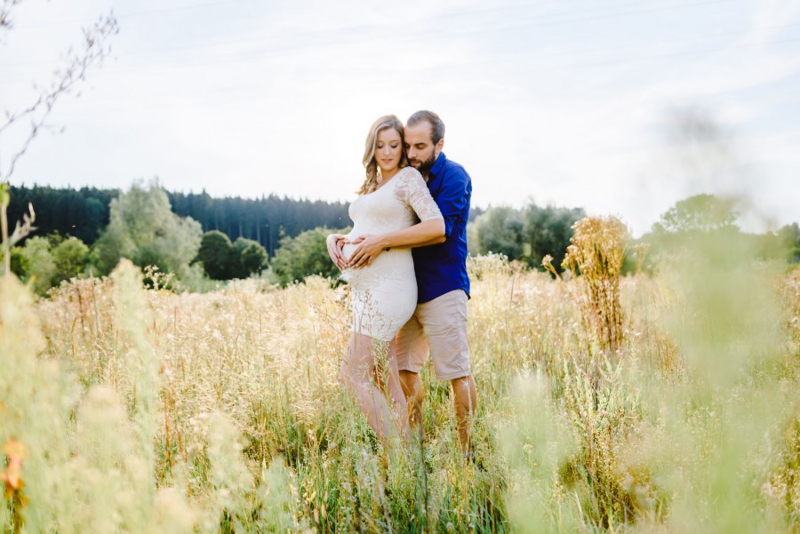 Angi_Chrissi_Irsee_00001 ein mann und eine frau, die sich in einem feld mit hohem gras umarmen.