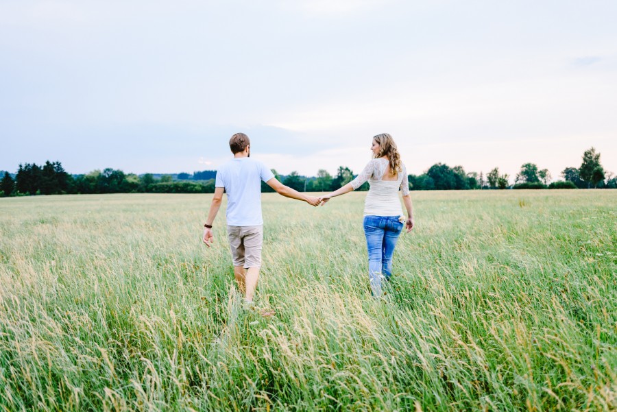 Angi_Chrissi_Irsee_00003 ein mann und eine frau halten sich an den händen auf einem feld.