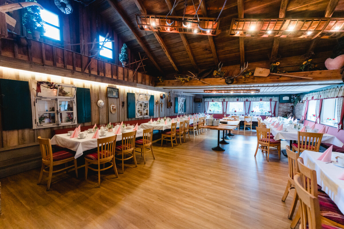 R_M_Bobingen_Langerringen_Hochzeit_00444_web ein Restaurant mit Tischen, Stühlen und Fenstern.