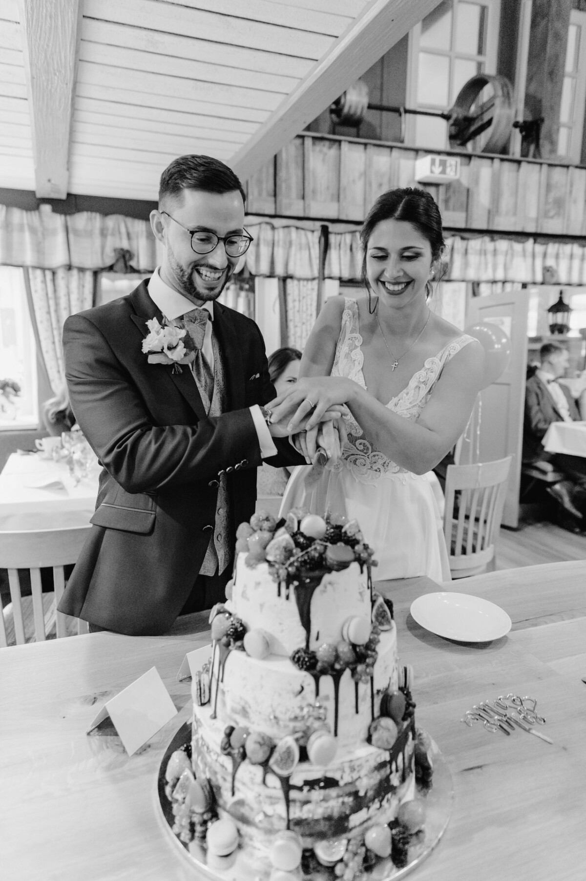 R_M_Bobingen_Langerringen_Hochzeit_00492_web Ein Mann und eine Frau schneiden gemeinsam einen Kuchen an.
