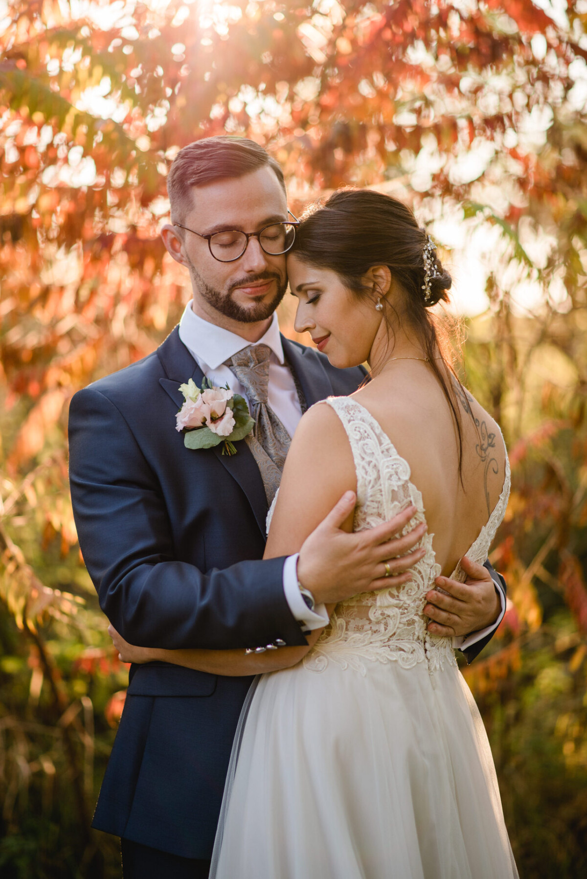 R_M_Bobingen_Langerringen_Hochzeit_00652_web Ein Brautpaar, das sich vor einem Baum umarmt.