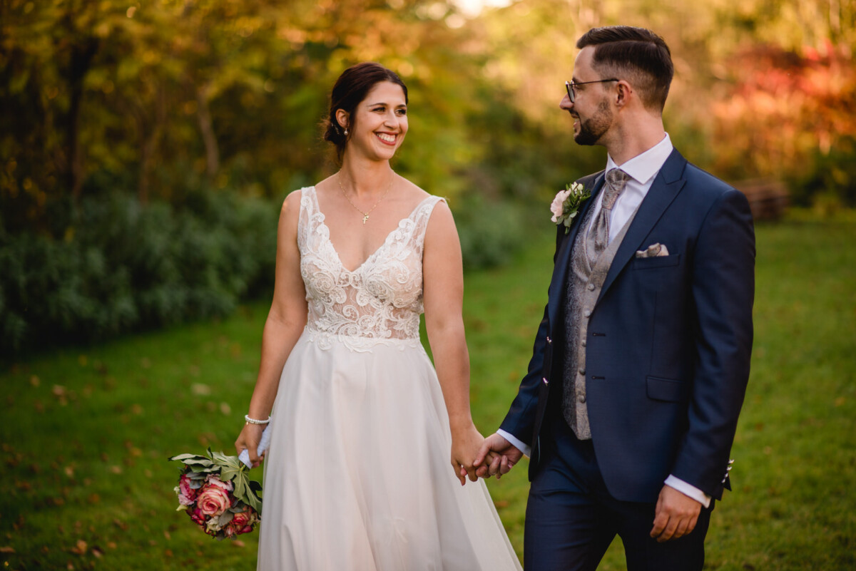 ein mann und eine frau halten sich an den händen auf einem feld.