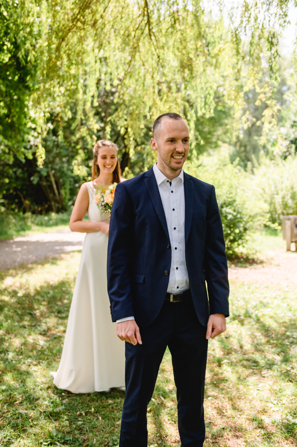 M_M_Bobingen_Kissing_Hochzeit_00001 Ein Mann im Anzug steht neben einer Frau in einem weißen Kleid.