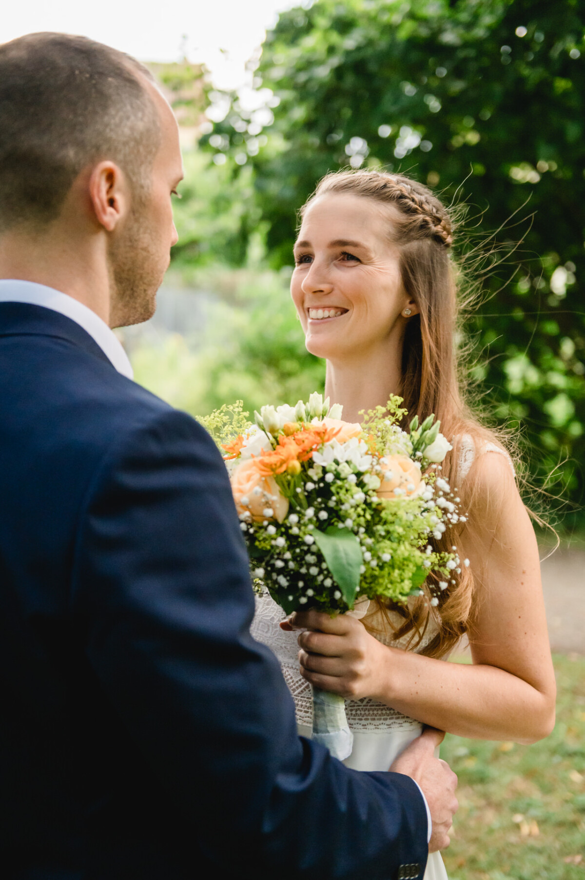 Ein Mann im Anzug hält einen Blumenstrauß in der Hand.