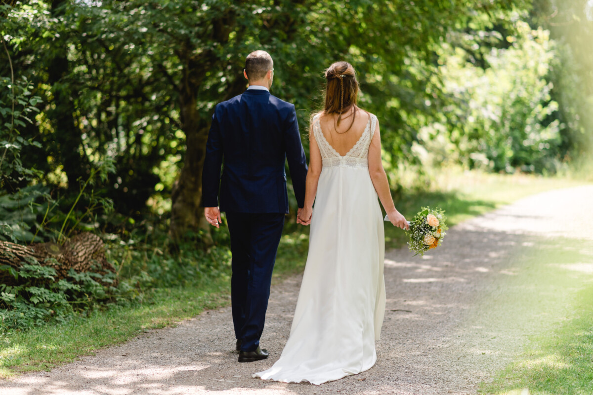 ein Brautpaar, das einen Weg hinuntergeht.