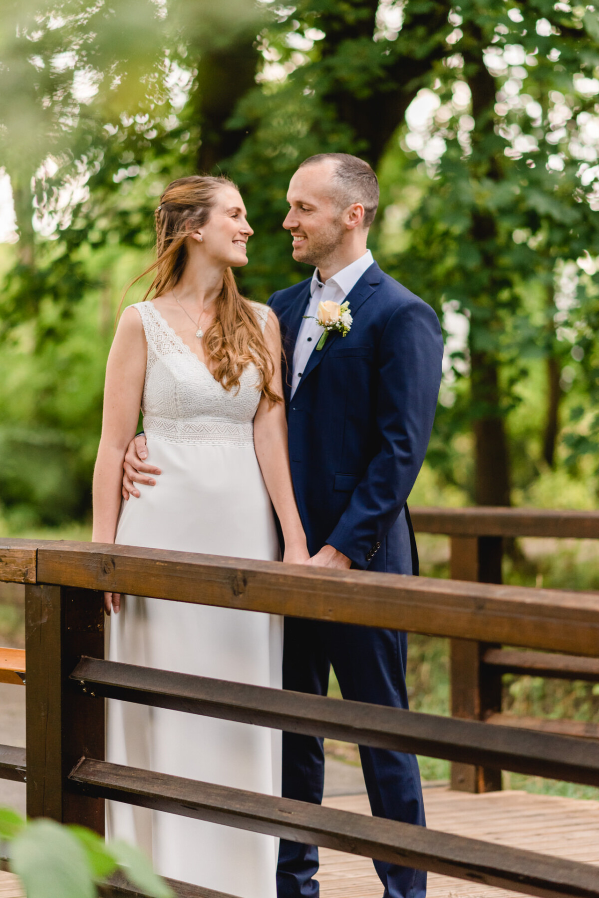 ein brautpaar, das auf einer brücke steht.