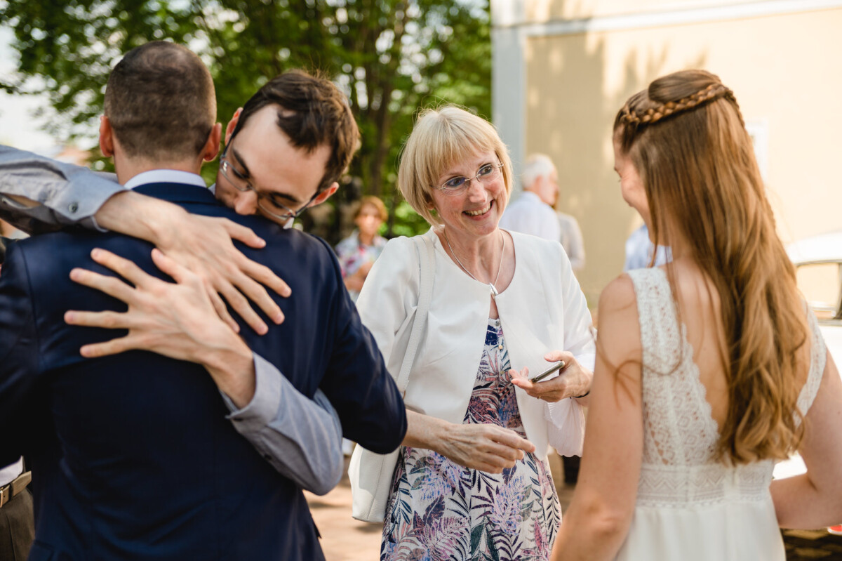 eine Gruppe von Menschen, die umeinander stehen.
