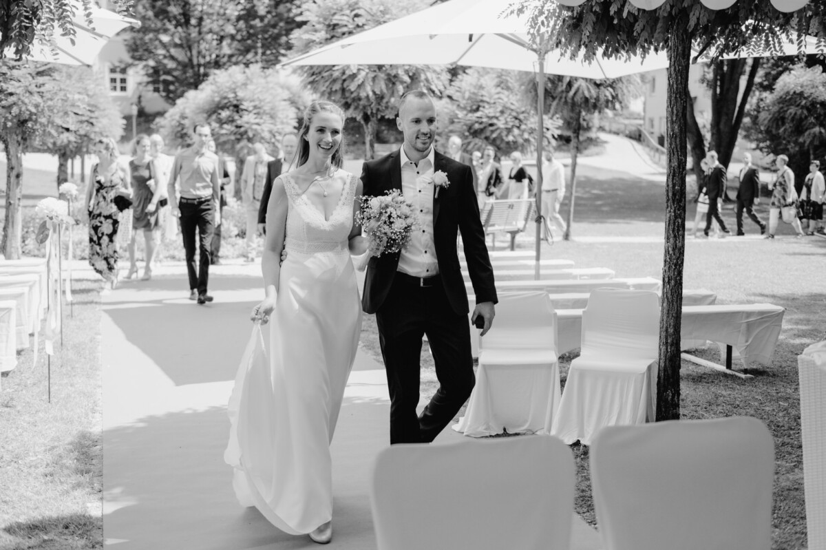 ein Brautpaar, das den Gang entlang geht.