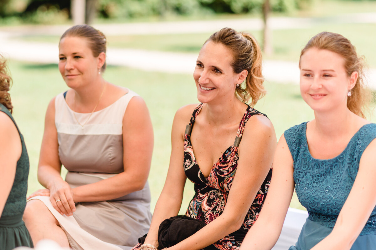 eine Gruppe von Frauen, die nebeneinander sitzen.