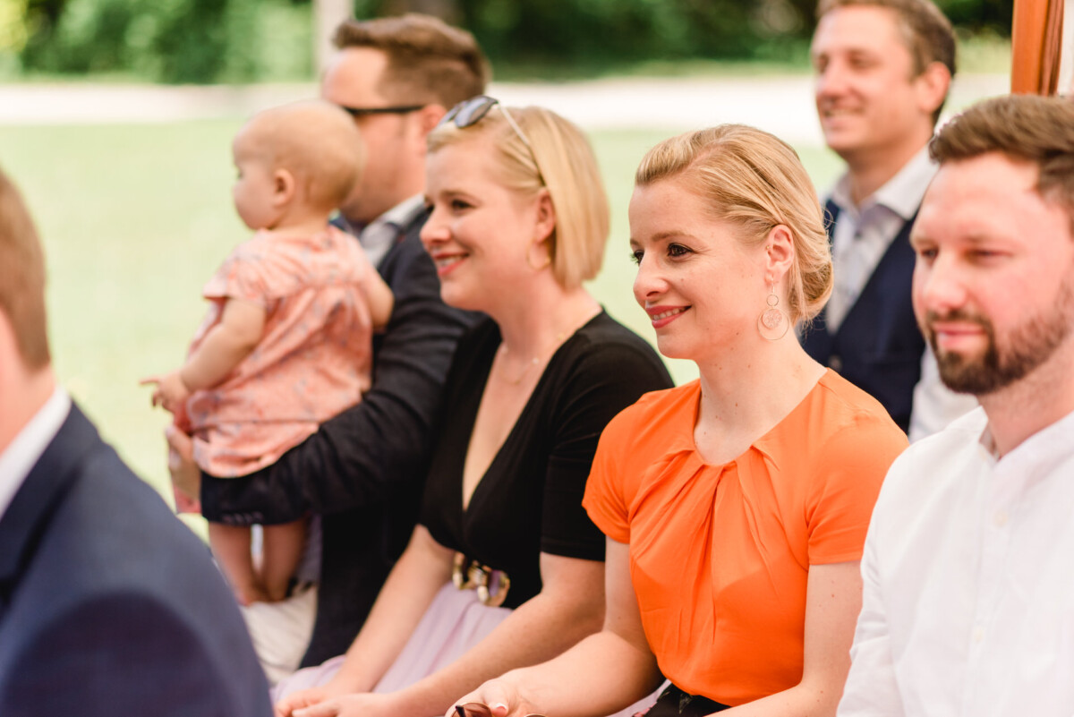 eine Gruppe von Menschen, die nebeneinander sitzen.