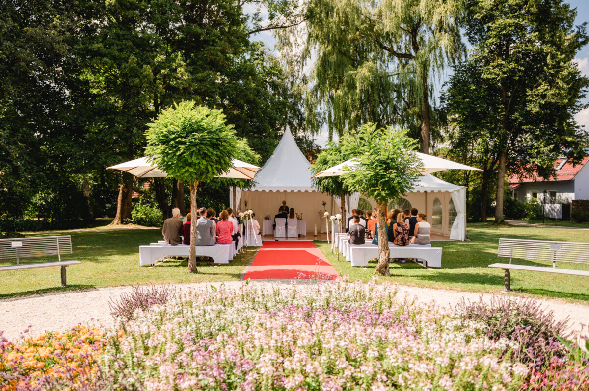 eine Gruppe von Menschen, die um einen roten Teppich herumstehen.