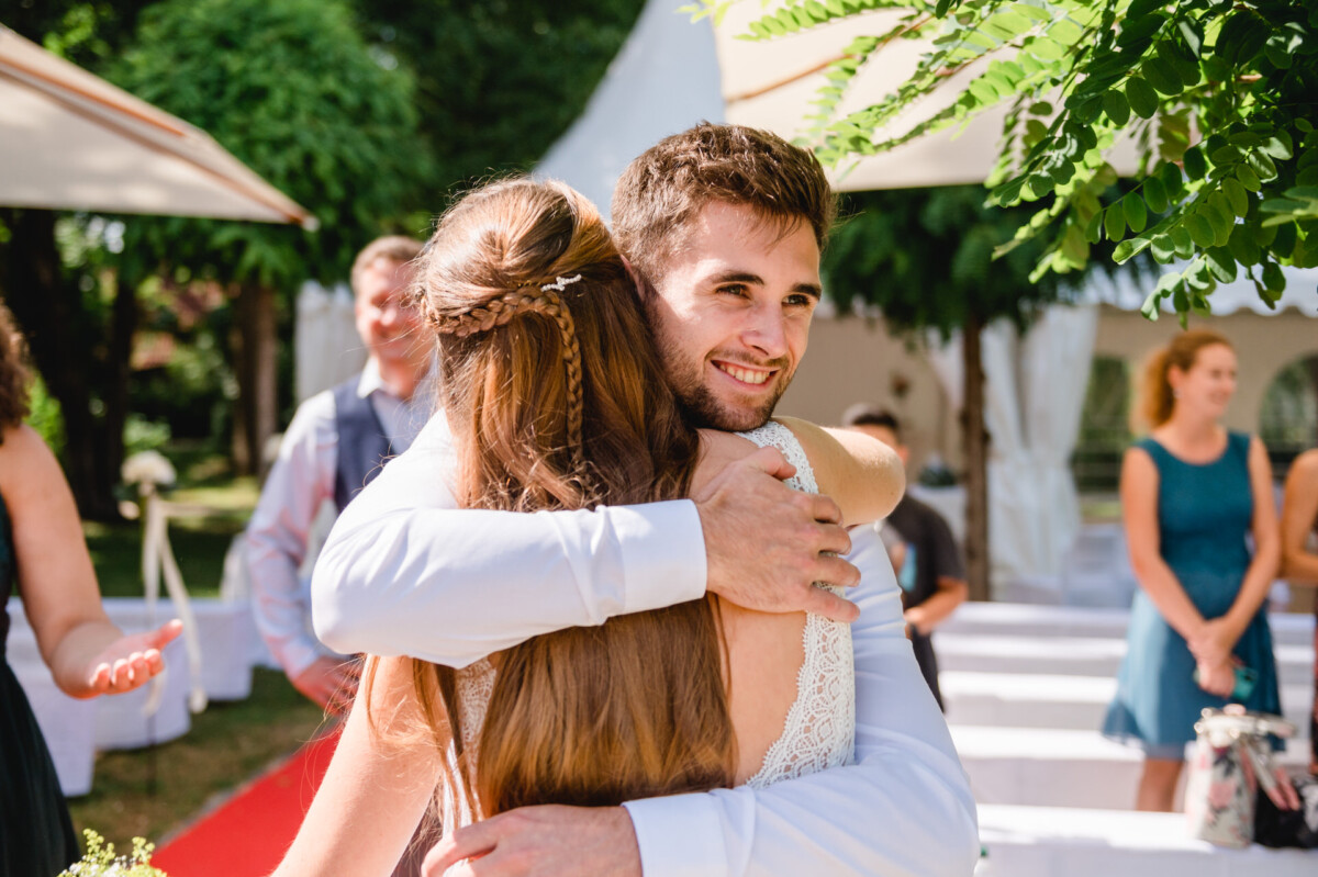 Ein Mann und eine Frau, die sich bei einer Hochzeit umarmen.