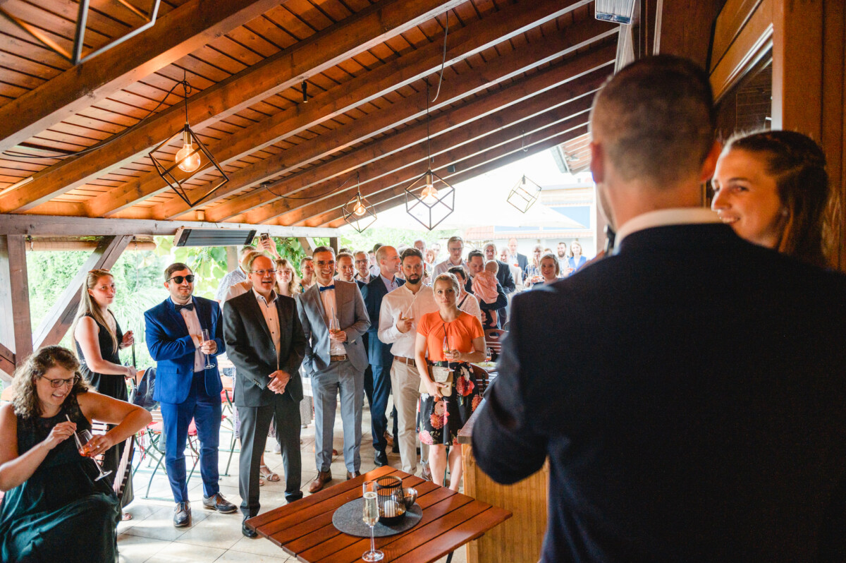 eine Gruppe von Menschen, die um einen Mann herumstehen, der eine Rede hält.