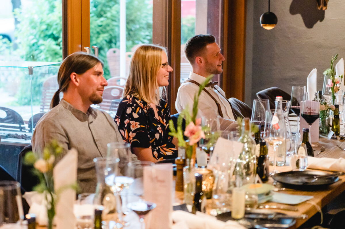 eine Gruppe von Menschen, die an einem langen Tisch sitzen.