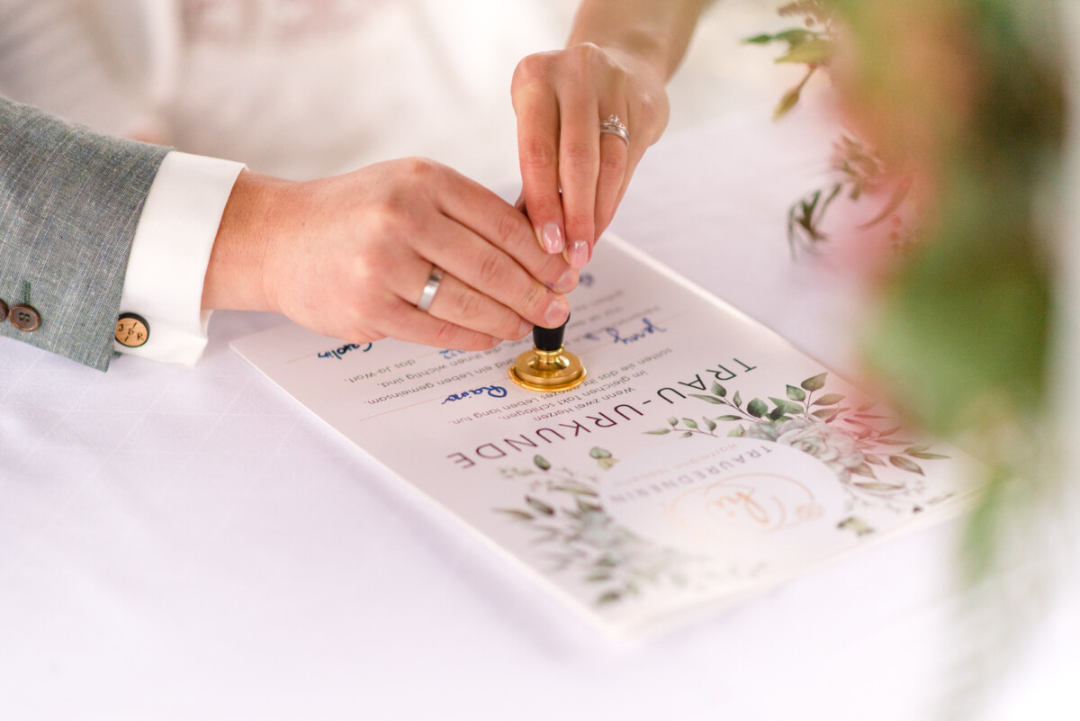 eine Person, die einen Ring auf eine Hochzeitskarte setzt.
