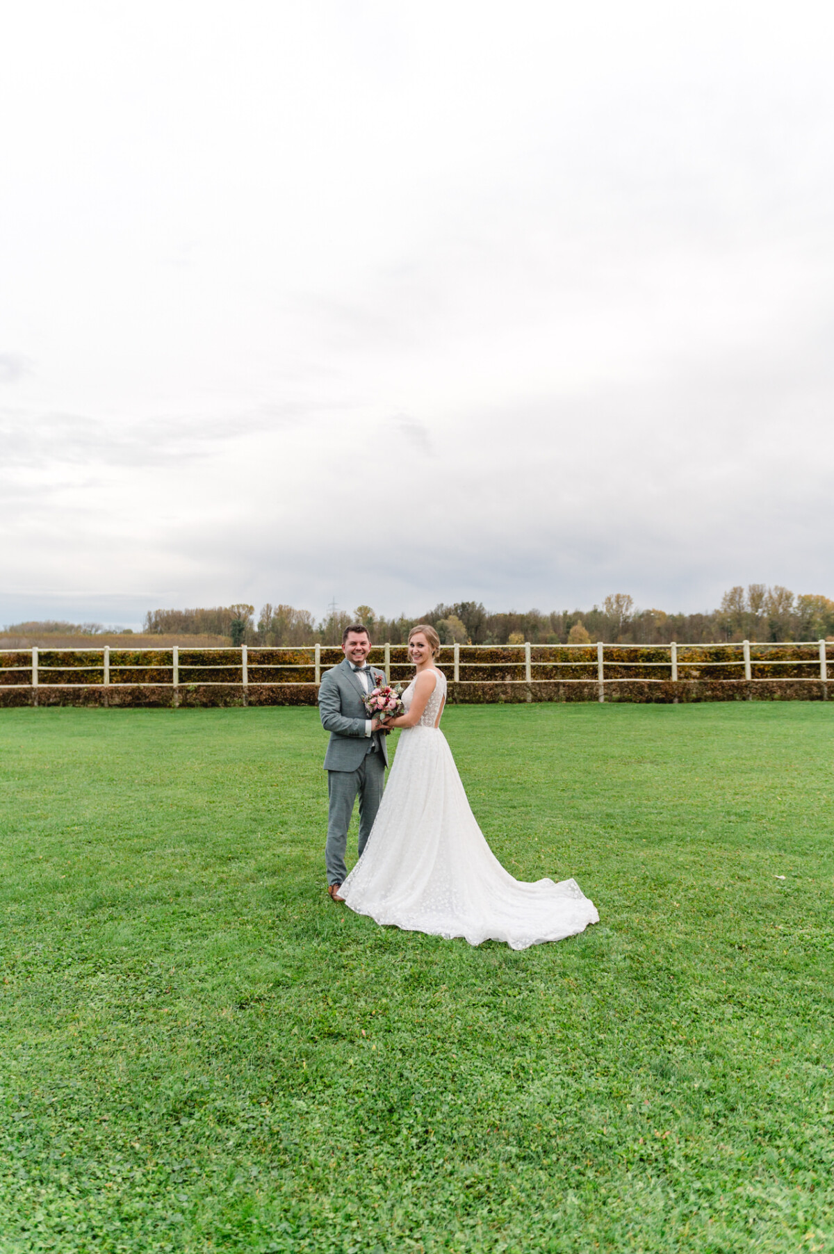 eine Braut und ein Bräutigam, die auf einem Feld stehen.