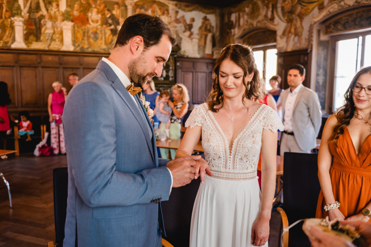 Eine Braut und ein Bräutigam tauschen bei einer Hochzeitszeremonie ihre Ringe aus.