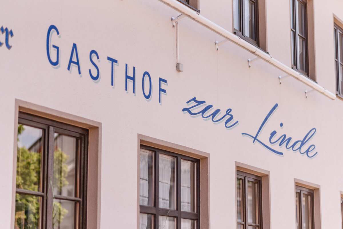 Ein Gebäude mit einem Schild mit der Aufschrift „Gasthof Er Linde“.