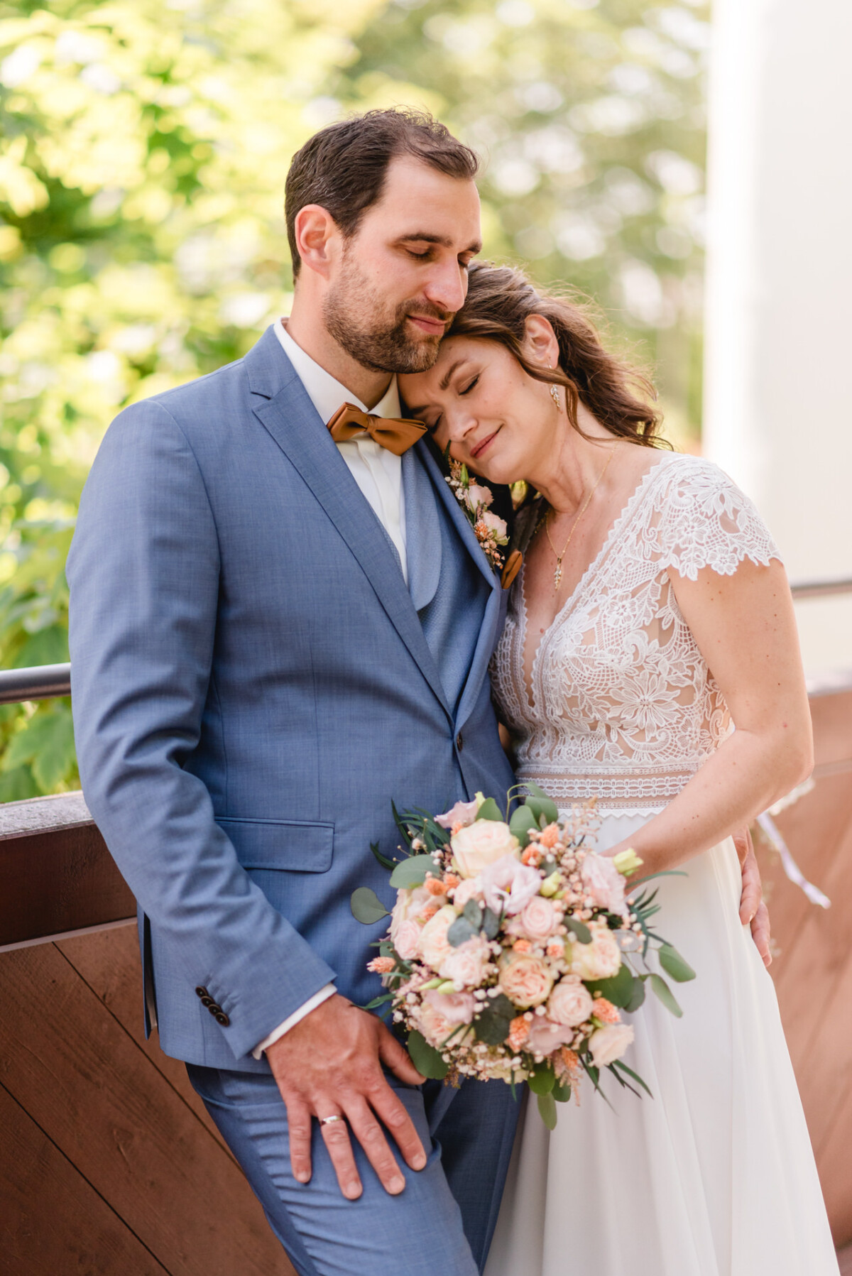 Eine Braut und ein Bräutigam umarmen sich auf einem Balkon.