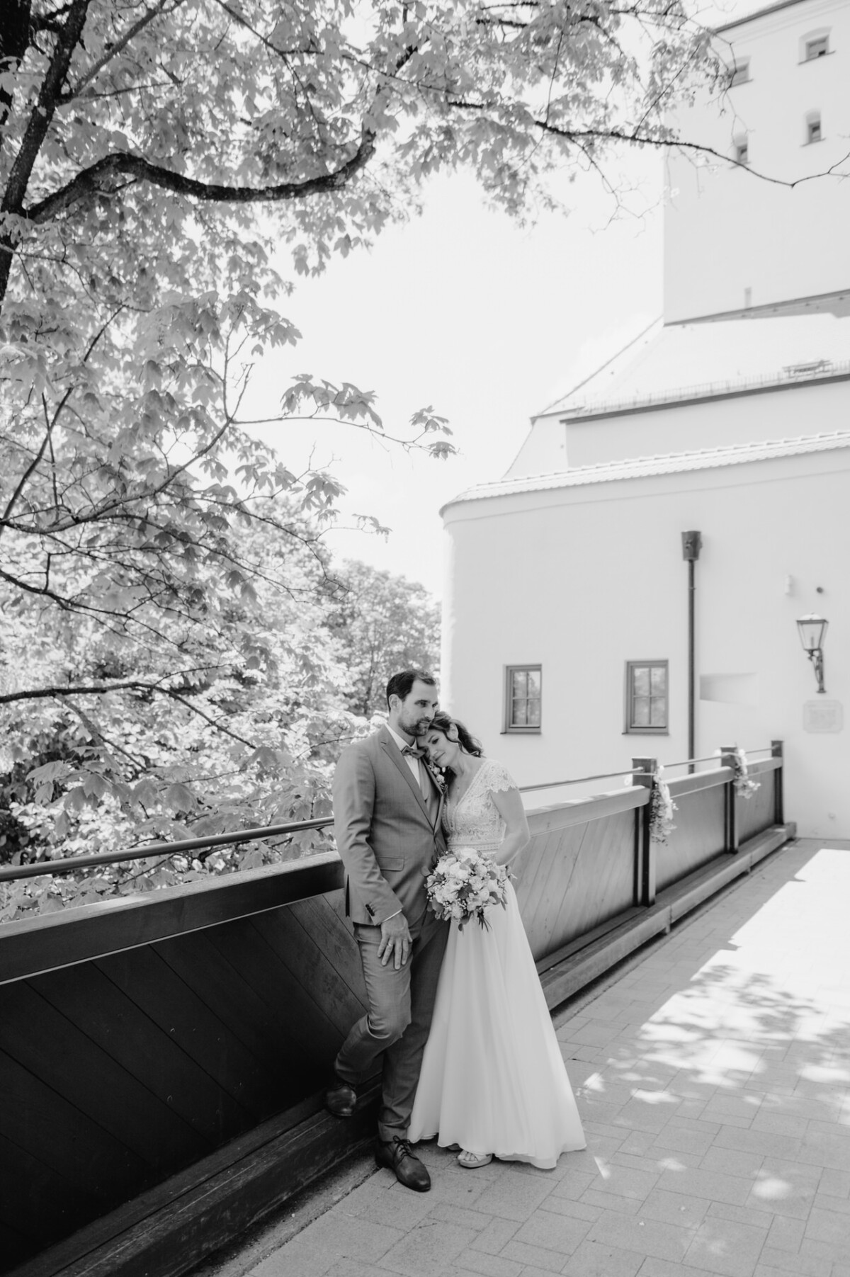 Ein Brautpaar posiert für ein Foto vor einer Kirche.