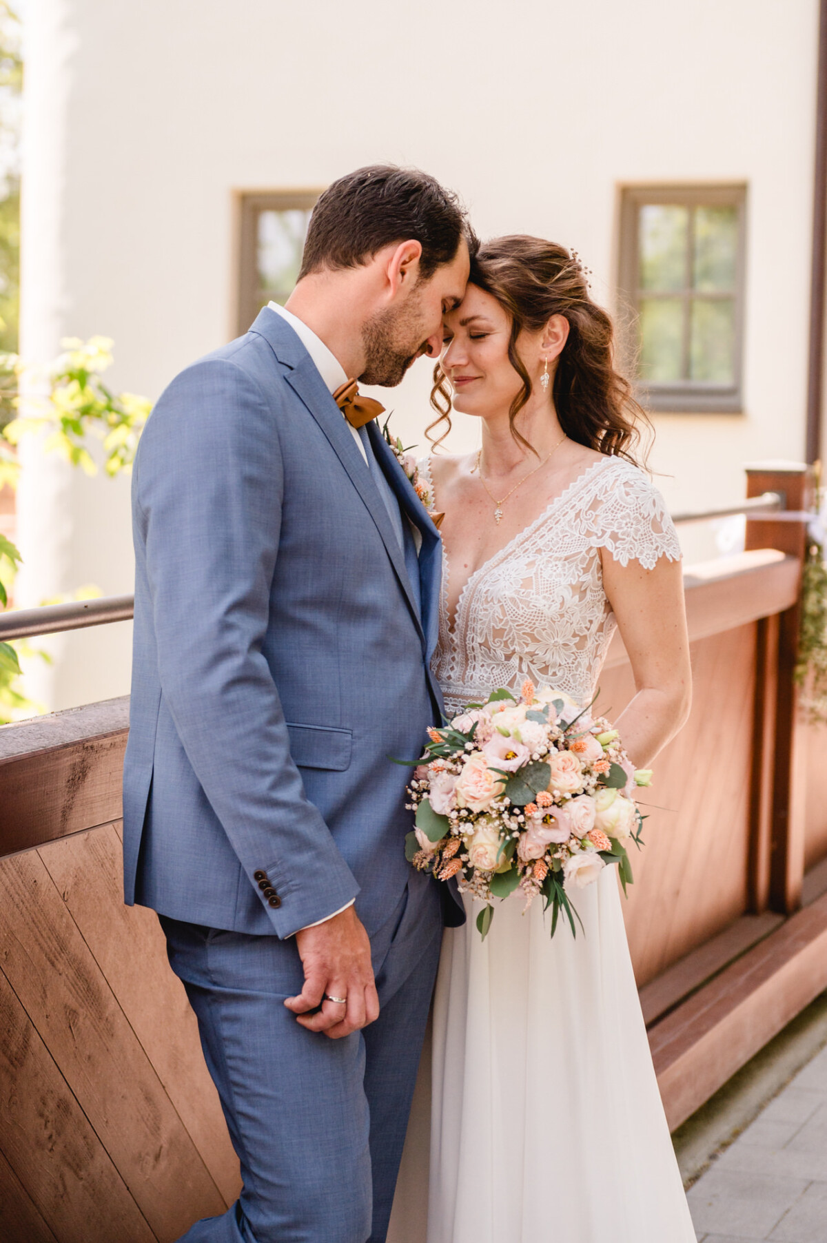 Eine Braut und ein Bräutigam umarmen sich auf einem Balkon.