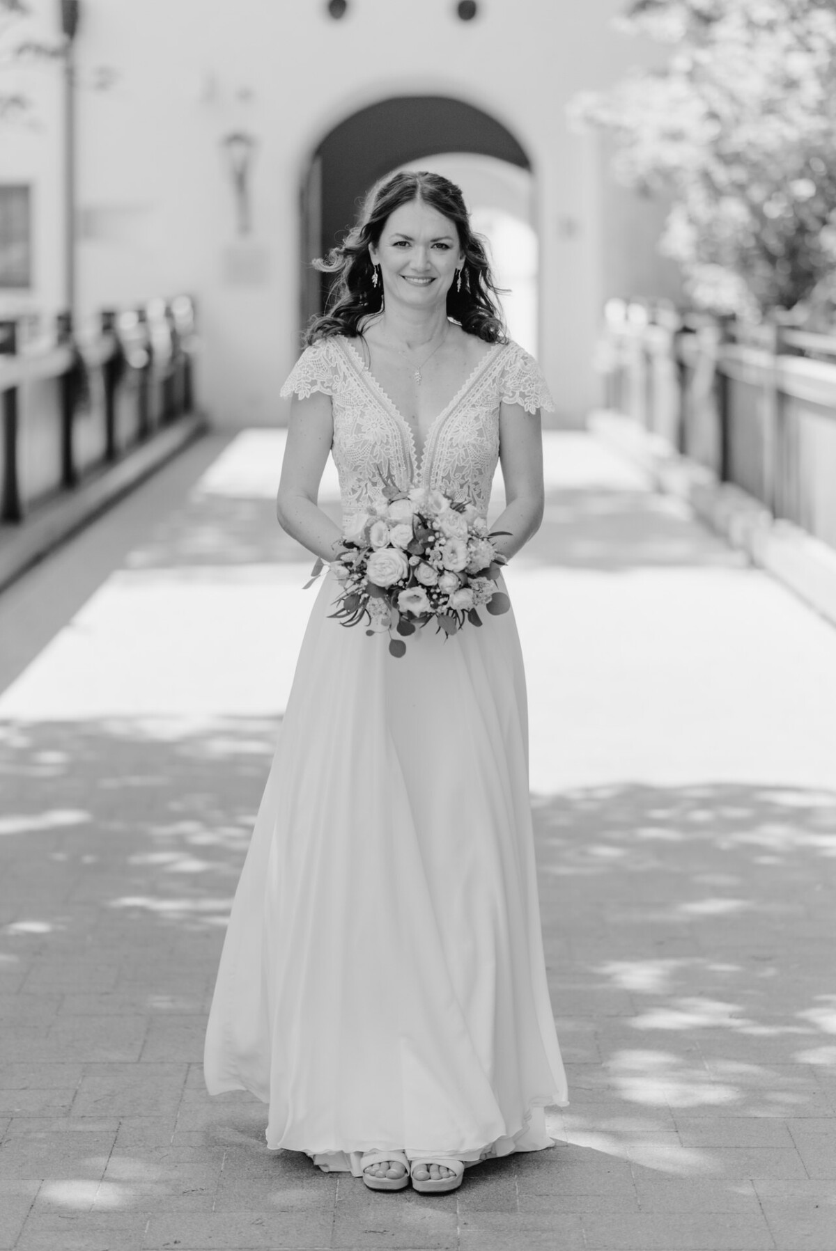 Schwarz-Weiß-Foto einer Braut, die eine Brücke hinuntergeht.