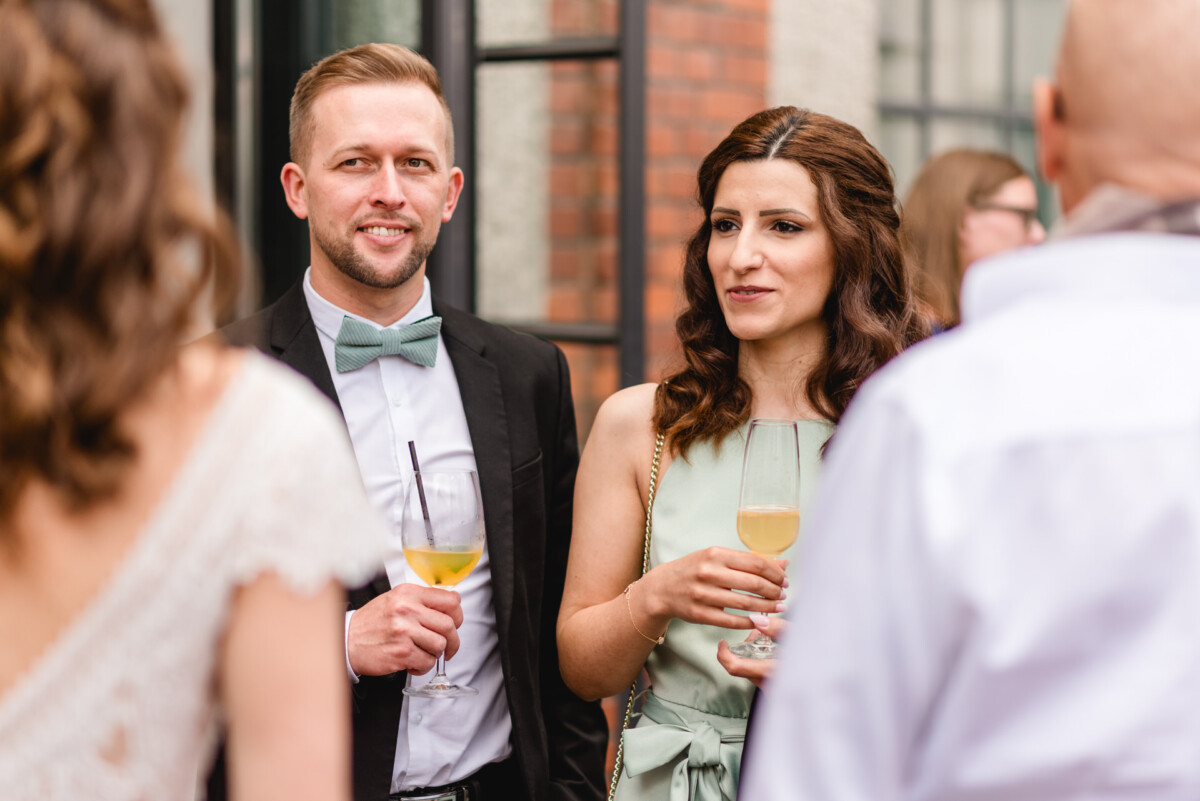 Eine Braut und ein Bräutigam trinken Wein bei einer Hochzeitsfeier.