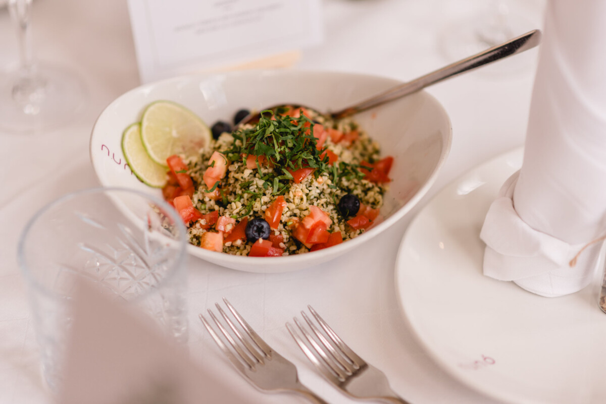 Eine Schüssel Salat auf einem Tisch bei einer Hochzeit.